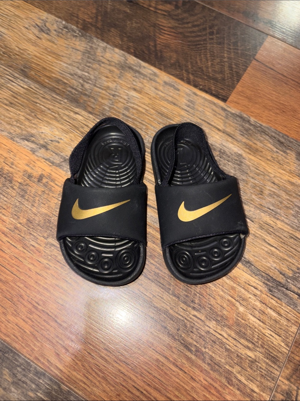 Nike Kids Black Slide Sandals with Gold Swoosh Accent